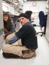 Christina Hammock and Jack Anderson work on a freezer