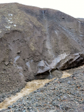 The loose rocks formed huge, steep mountains.  Anyone know what this is called?  The gray stuctures toward the bottom are blocks of ice.