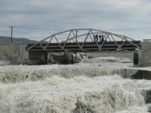 Students on the bridge conducting flow rate experiments