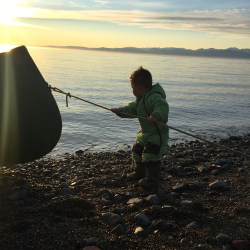 Young Inuit boy helping out with one of the boats