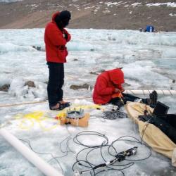 Sasha and Justin adjusting sediment trap.  Drill hole is in foreground with drop camera and computer nearby.